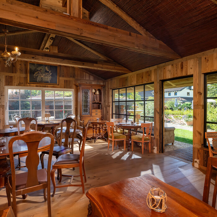 Blick in das Bademantelrestaurant mit großen Fenstern in den Hotelgarten